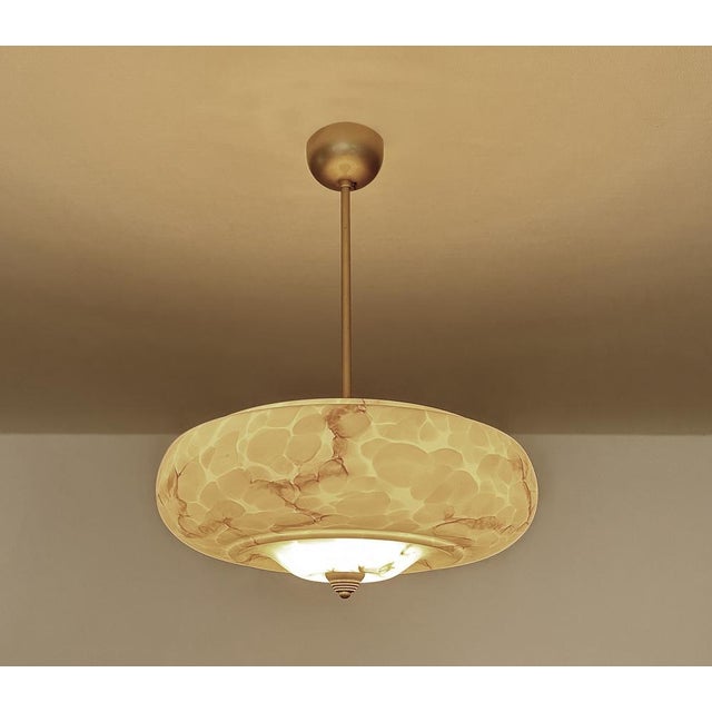 Art Deco pendant lamp from the 1930s, mottled ivory / light amber marble glass shade with darker veins, brass finial,...