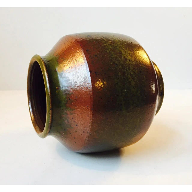 This vase in an earthy green, red, and golden brown solfatara glazes was designed by award-wining Danish ceramist Marianne...