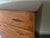 A handsome mid-century chest of drawers in warm walnut veneer, standing on slender tapered splayed legs with metal tips....