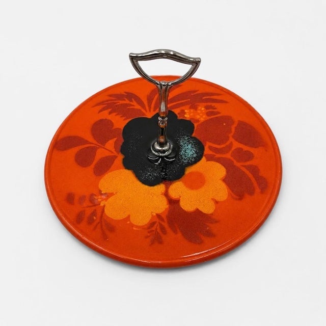 A little taste of the seventies for your table! This glazed ceramic cheese board features a spectacular stylized floral...