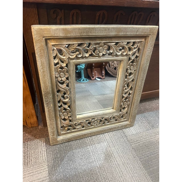 Beautiful floral motif ornate carved mirror with a gold wash Measures 22 1/4 inches wide by 25 inches tall and one and...