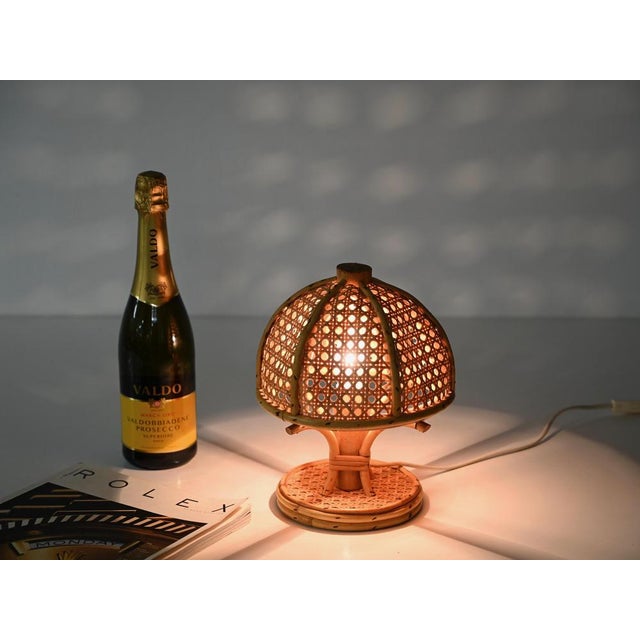 Stunning pair of french riviera style table lamps entirely crafted in bamboo, curved rattan, and vienna straw. These...