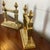 This pair of circa 1885 solid brass fireplace chenets are ornamented with aesthetic movement motifs including birds within...