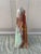 A beautifully proportioned marble obelisk in richly veined shades of green, brown, cream, and tan. The sculptural...