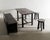 A rare french mid century wooden dining set consisting of a sofa, table and pair of stools in dark stained oak by an...
