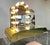 Elegant lucite single drawer vanity with light up arched mirror having brass toned accents along the corners and front...