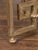 A French vintage silver leaf iron center table from the mid-20th century, with circular glass top and Greek Key motifs....