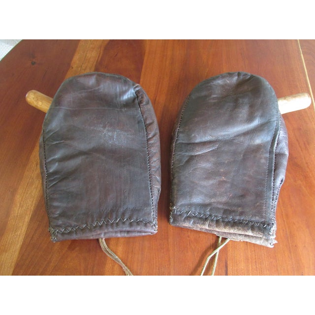 Rare pair custom made circa 1930s thumbless leather boxing gloves. The pair feature wooden inserts which fit within...
