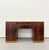 A streamlined Art Deco desk showcasing richly figured burl wood across its symmetrical pedestal form. Two central drawers...