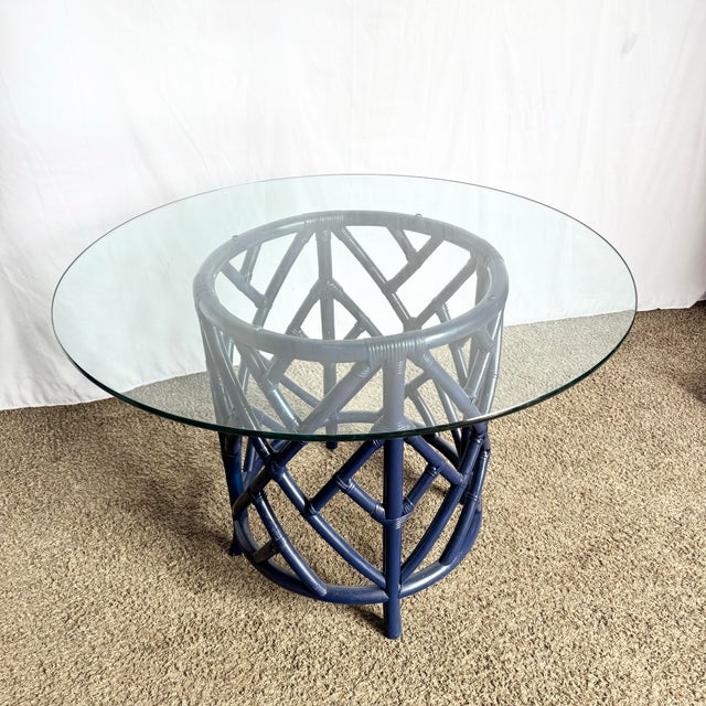 A bold twist on a coastal classic, this dining table features a navy blue rattan base in the iconic Chippendale lattice...