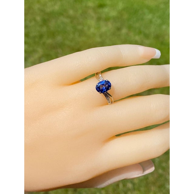 The Mountain Pass: White Gold Diffused Sapphire Bypass Ring. The ring features a central diffused sapphire with flowing...