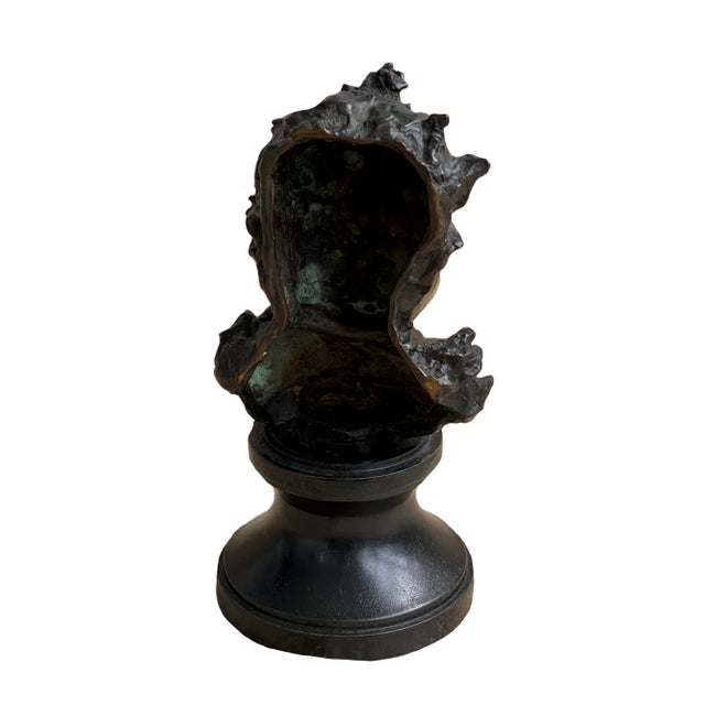 An American figural bronze bust of a child mounted on a wooden plinth by American sculptor, George Conlon. Inscribed...