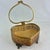 This vintage gold tone heart shaped jewelry box features an intricate ormolu filigree design with a clear glass lid....