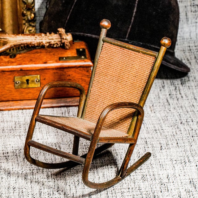 A charming example of early woodworking skill, this handmade antique miniature rocking chair radiates rustic character and...