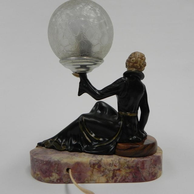 Height: 25 cm. Width: 20 cm. Depth: 10 cm. The wooden disc where the woman is seated on has been renewed by us. The lamp...