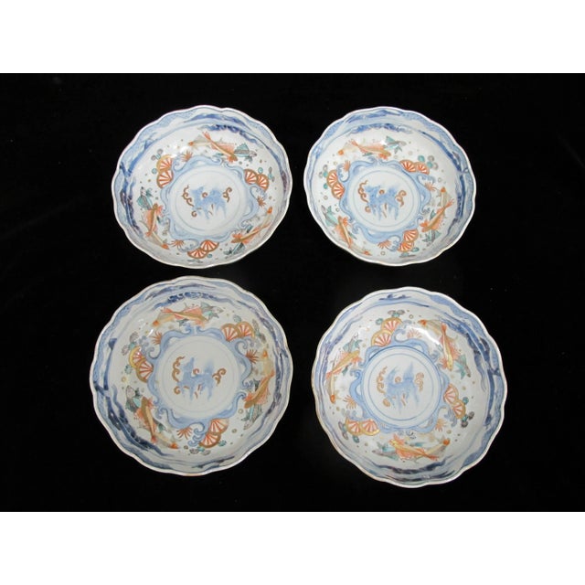 Gorgeous Japanese Imari porcelain bowl set of 4. Each beautifully hand painted Kirin, fish, and fan design at inner bowl....