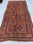 This antique hand-knotted Khamseh Qashqai rug features two columns of compartmentalized star medallions in rust, ivory,...