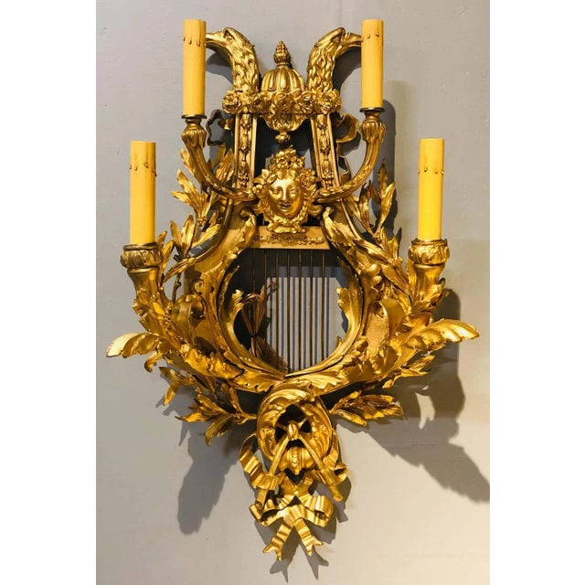 Pair of four-light Louis XVI style bird and face mounted gilt bronze wall sconces. This newly wired and restored pair of...