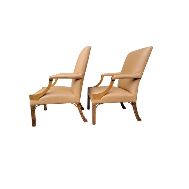 A Pair of Reproduction English Gainsborough or Library Chairs, made of Mahogany with blind fretwork on the arms and legs...