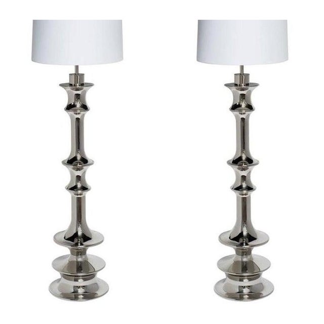 Pair of tall dramatic Hollywood Regency floor lamps with architectural design. Lamps feature highly stylized baluster...