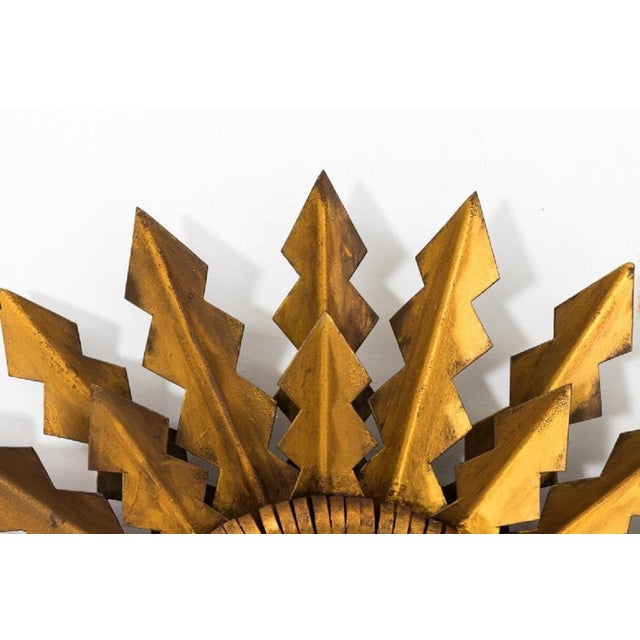 Brilliant gilded toleware sunburst round mirror, made in Spain in the early 20th century. Gilt arrows radiate from the...