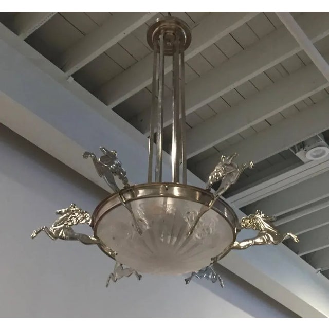 Stunning French Art Deco chandelier signed by Degue. Having six deco mythical horses surrounding the center glass bowl....