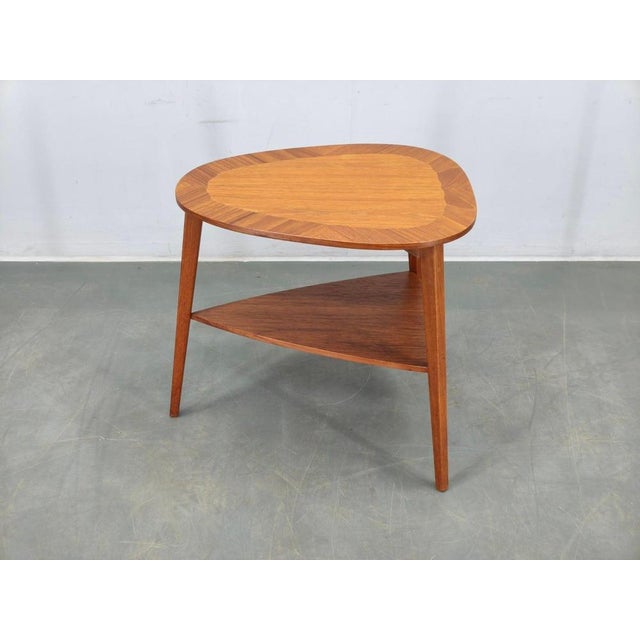 Refined danish mid century coffee table from the 1960s, crafted in solid teak with a teak veneered top and matching lower...