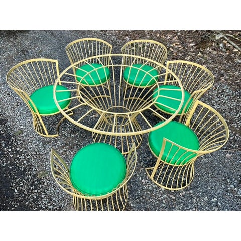 A matching 7 piece mid century modern style iron outdoor dining set including a 47" diameter round dining table with 24"...