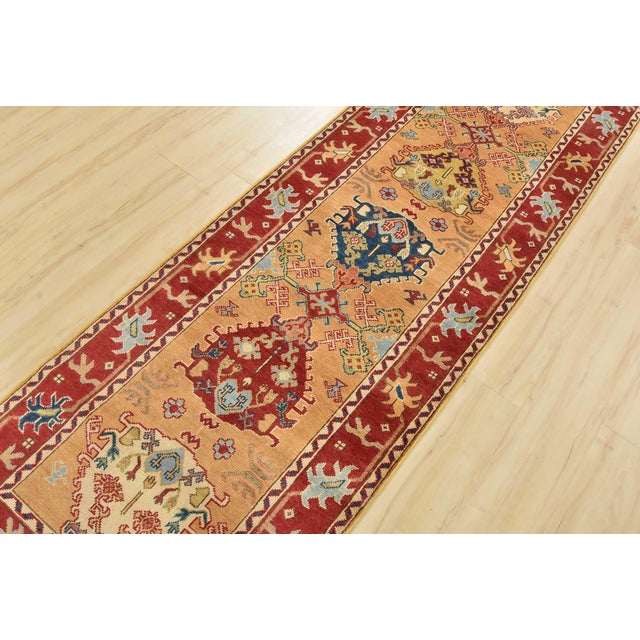 A traditional tribal Caucasian Kazak runner hand-knotted with an all-wool pile on a cotton foundation. This oriental rug...