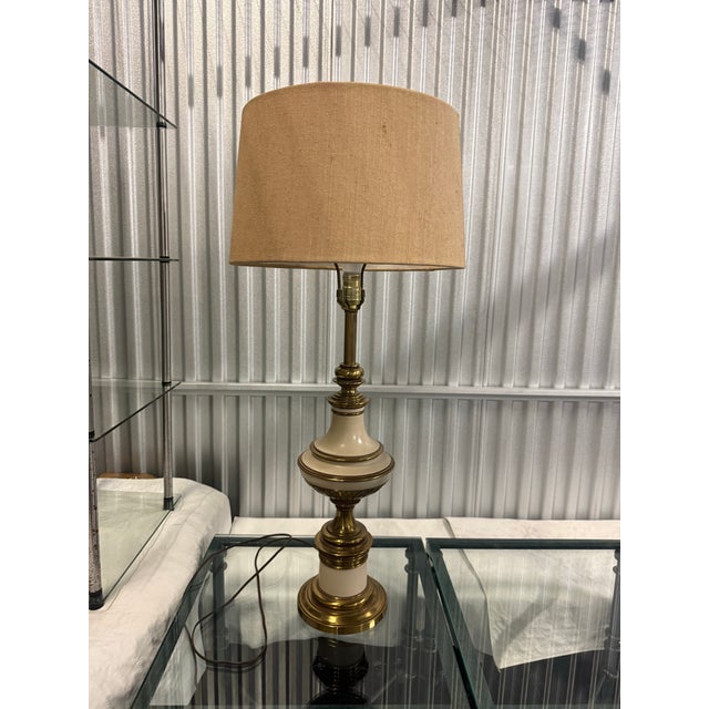 Beautiful vintage Stiffel table lamp featuring an elegant cream finish with detailed brass-tone accents. The lamp has a...