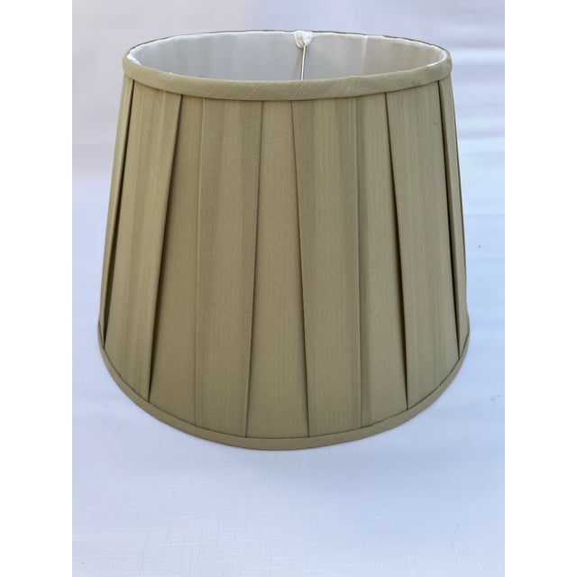 A single round empire shape lamp shade with open box pleat in a light green fabric. Uno fitting base is 7.5" from top....