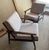 A striking pair of mid-century modern lounge chairs featuring a solid wood frame with beautifully sculpted arms and...