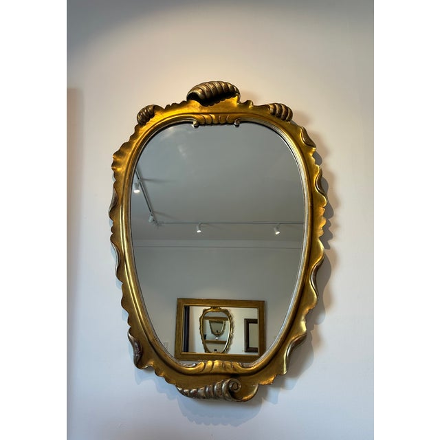 Italian midcentury, gilt and silvered wood frame mirror with an ocean wave motif throughout the carved shaping. Original...