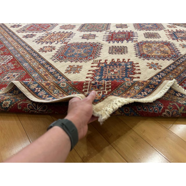 This is a Super Kazak rug handmade in Afghanistan, featuring a traditional Caucasian-inspired design with sunburst...