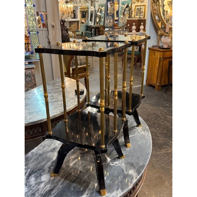 Decorative pair of Jansen Manner black lacquered and brass side tables. Made of quality materials, these items make an...