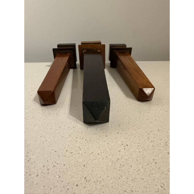 Striking set of three vintage decorative wooden obelisks in a two-tone black and warm brown finish. The trio features...