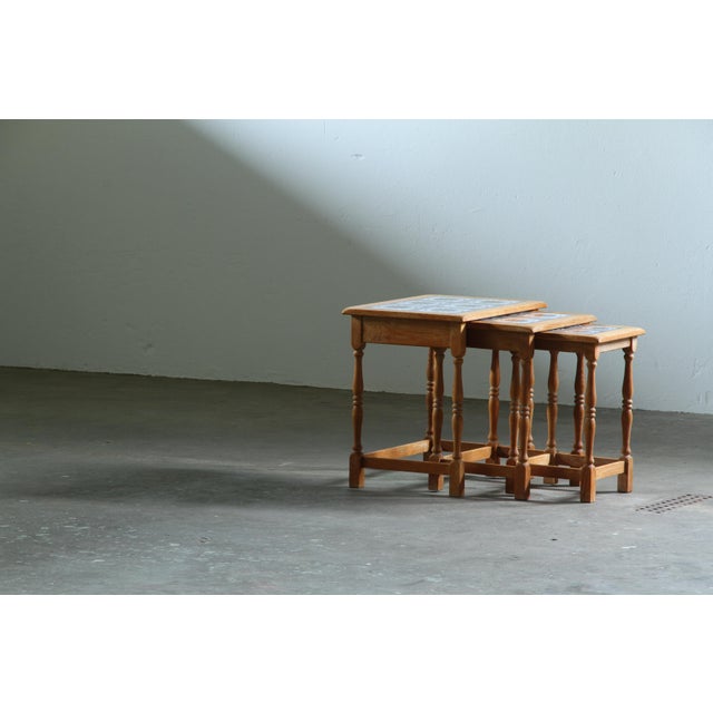 A set of three Danish oak nesting tables from the 1970s, designed to slide neatly beneath one another when not in use....