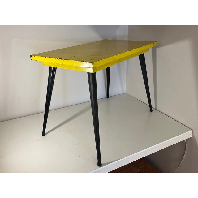 Great table in the style of Tolix with black legs and a yellow tabletop. All made of metal.