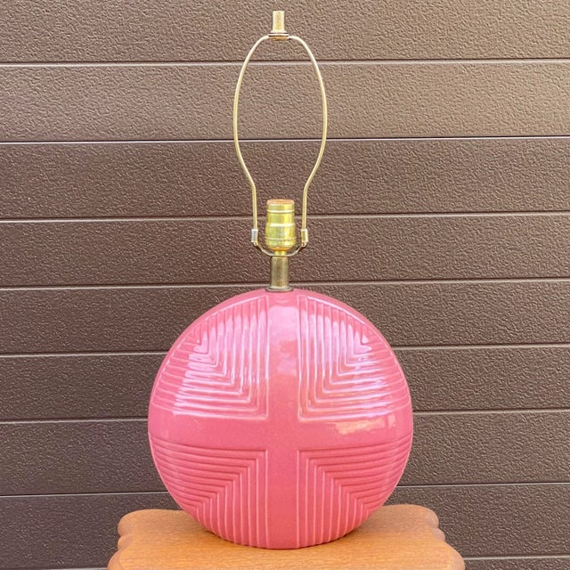 A unique vintage ceramic lamp with blush pink glaze and geometric pattern throughout. 15.5” tall to top of bulb socket....