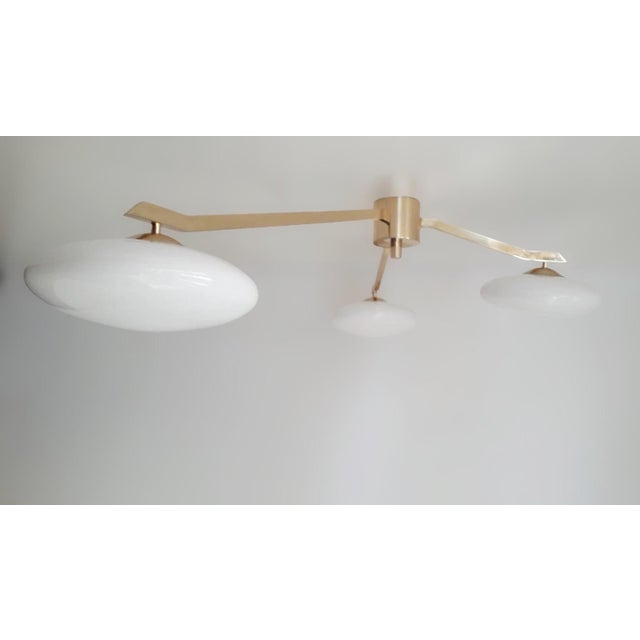 Italian flush mount with three glossy white Murano glass shades tiered at different heights, mounted on solid brass frame...