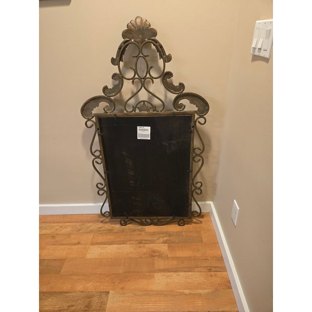 Substantial, vintage, antique bronze wrought iron mirror with elaborate scrollwork detail, beveled edge, and elaborate...