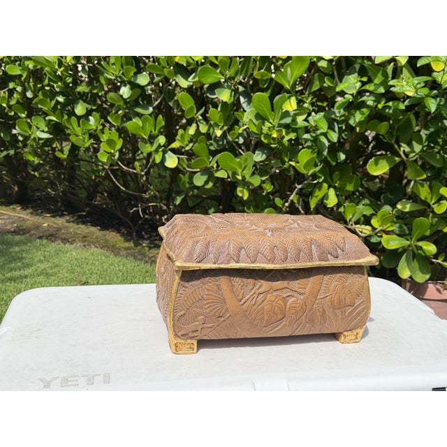 Striking vintage decorative box featuring elaborate hand-carved tropical foliage and animal motifs throughout, accented...