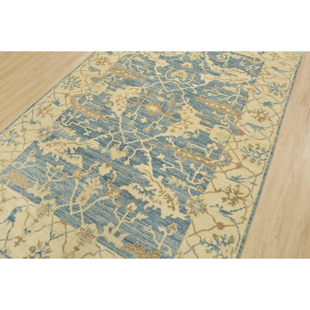 A modern traditional Oushak rug, hand-knotted with fine wool on a cotton foundation. This area rug features a central...