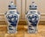 Elegant pair of blue and white chinoiserie porcelain ginger jars with matching lids, featuring richly detailed landscape...