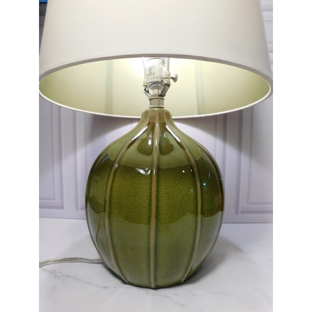A matching pair of Tanner Kenzie ceramic table lamps from Arteriors Home with an organic gourd shape and avocado green...