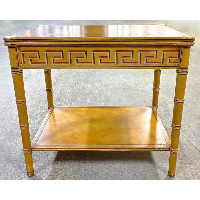 Vintage painted Greek key side table with lower shelf. The legs are finishe to give a bamboo-like effect. The rounded...