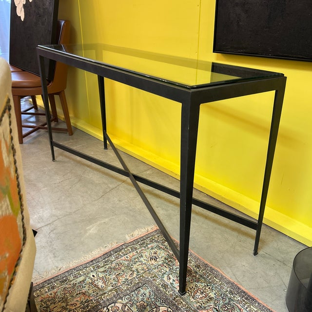 Steel and beveled glass top industrial and brutalist console table with bottom x- frame stretcher. Industrial in design...