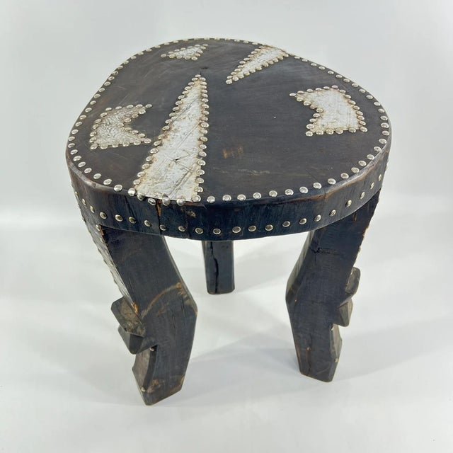 The Tabwa Stool with metal accents, originating from the Democratic Republic of Congo, stands as a striking example of the...