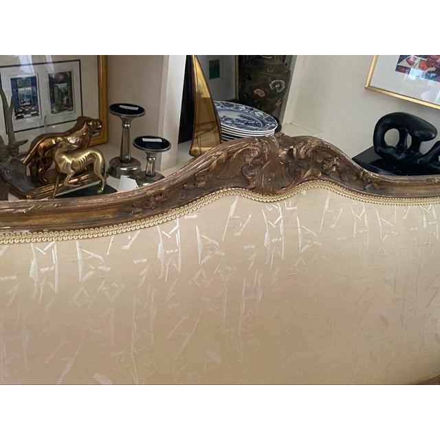 Elegant French Louis XV-style giltwood settee featuring a hand-carved crest rail with floral and foliate motifs,...