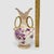 Up for sale is a beautiful vintage porcelain vase featuring a delicate hand-painted purple floral motif wrapped in pink...